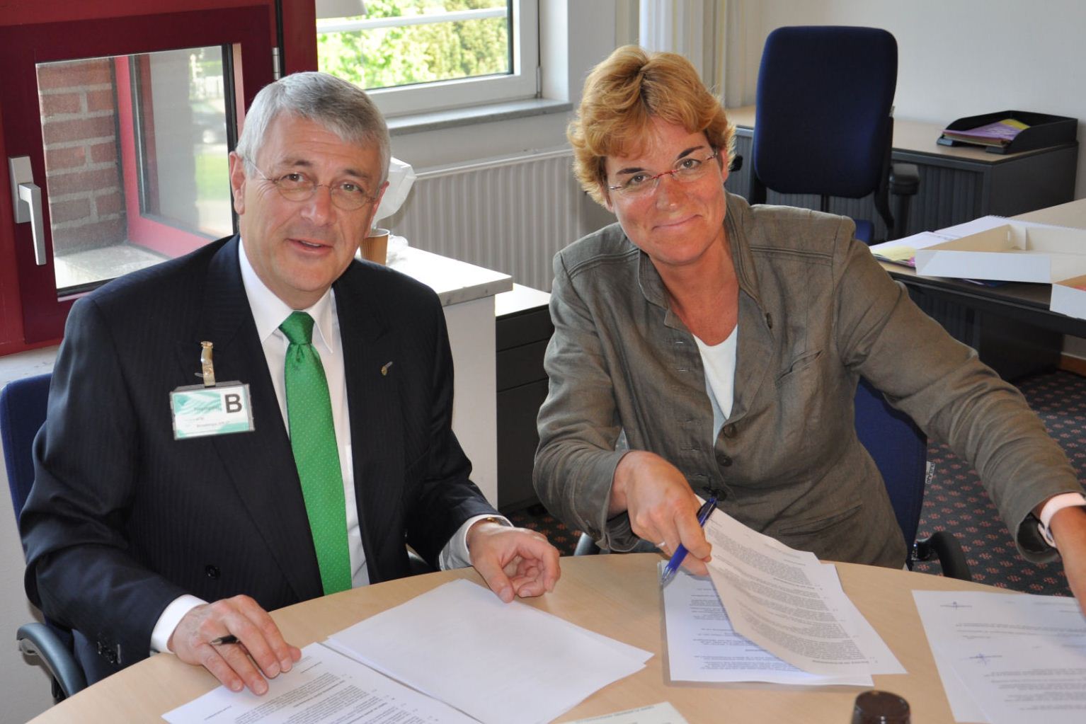 Ingrid van de Boel (FM Haaglanden) en Tom Stuij (Mondial Movers)bij tekenen contract.